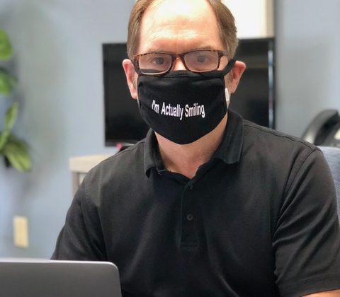 Man wearing mask with message. "I'm Actually Smiling".