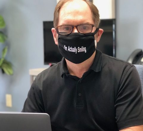 Man wearing mask with message. "I'm Actually Smiling".